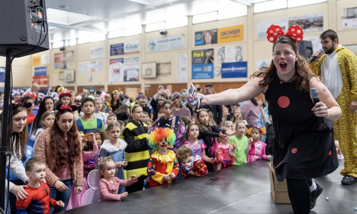 Singende verkleide Frau mit Mikrofon in der Hand