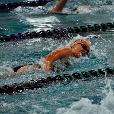 Einen Schwimmerin im Wettkampf mit Kraulstil