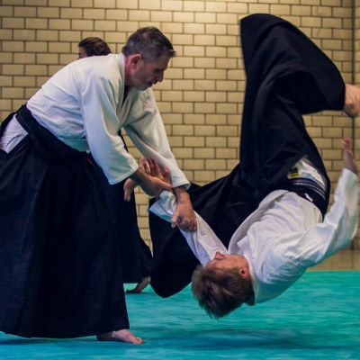 zwei aikidokämpfer einer legt den anderen auf den rücken
