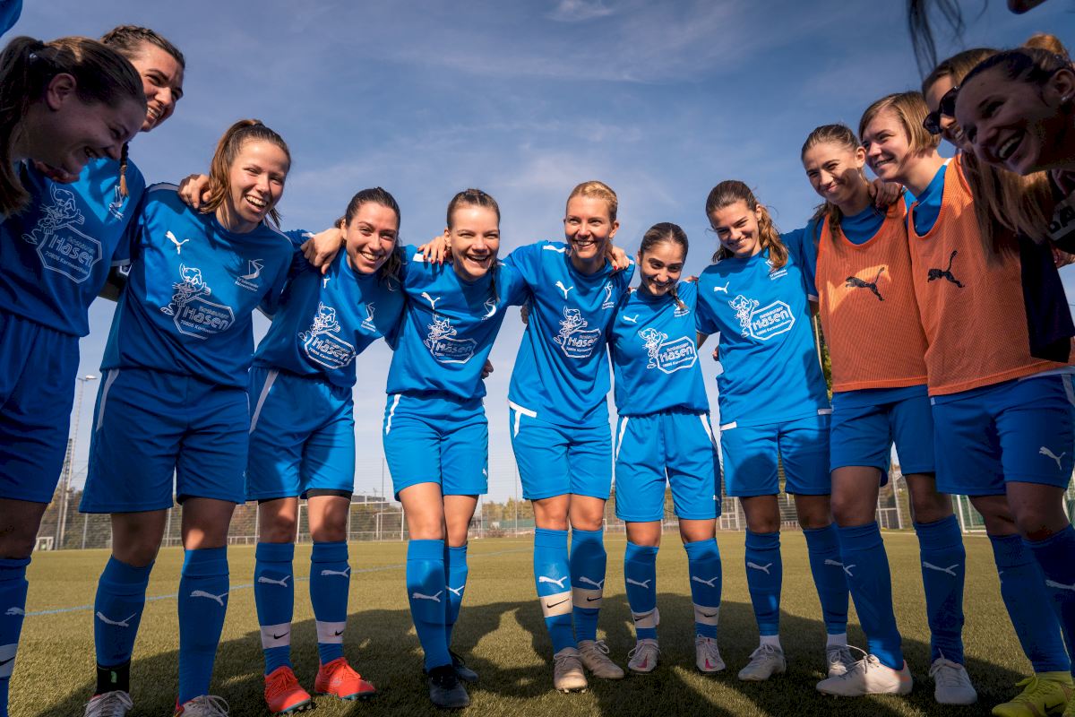 Frauenmannschaft der Fußballerinnen bilden einen Halbkreis